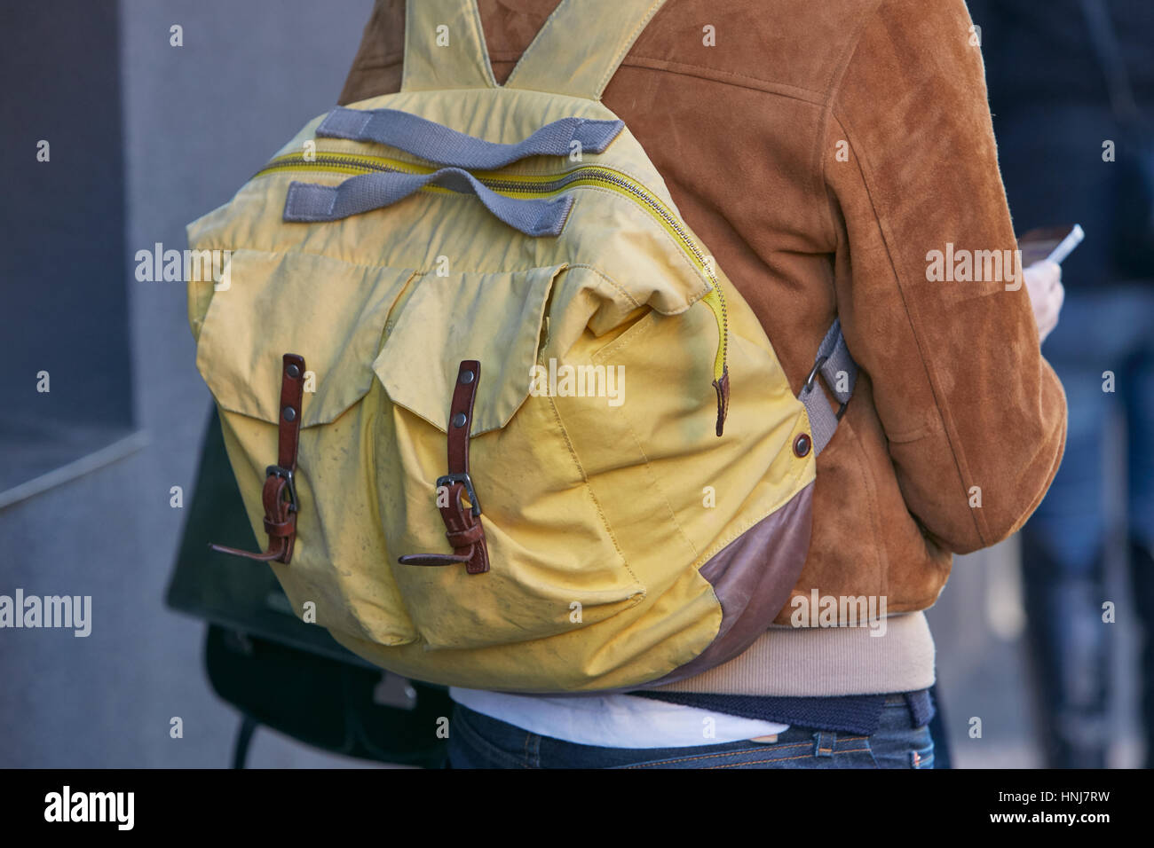 Homme avec sac à dos en tissu jaune et marron veste en daim avant fashion show, Etro Milan Fashion Week street style le 16 janvier 2017. Banque D'Images