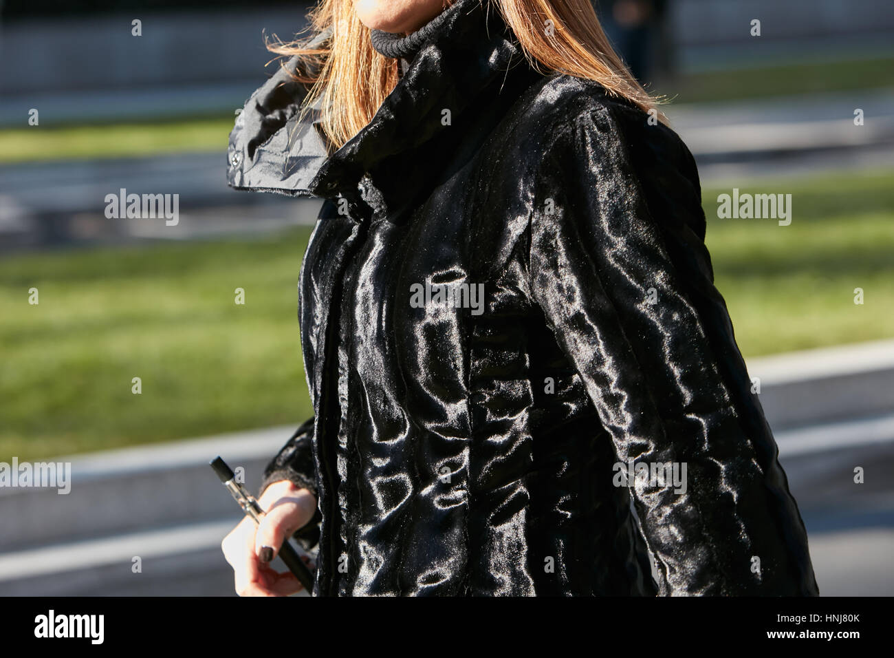 Femme avec brillant noir manteau de fourrure avant de Giorgio Armani fashion show, Milan Fashion Week street style le 17 janvier 2017 à Milan. Banque D'Images