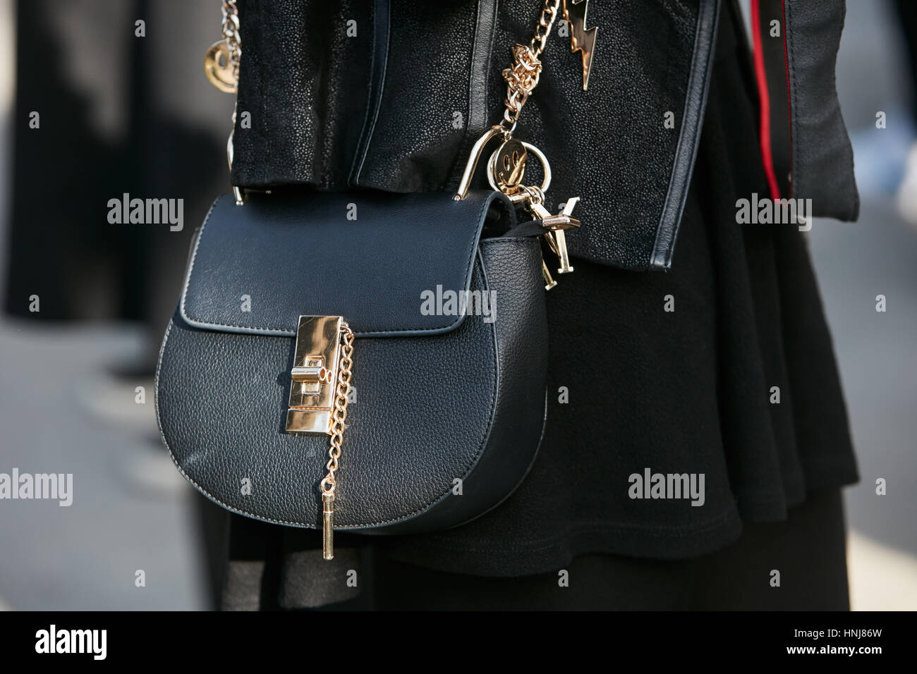 Femme avec sac en cuir noir avec détails dorés avant de Giorgio Armani fashion show, Milan Fashion Week street style le 17 janvier Banque D'Images
