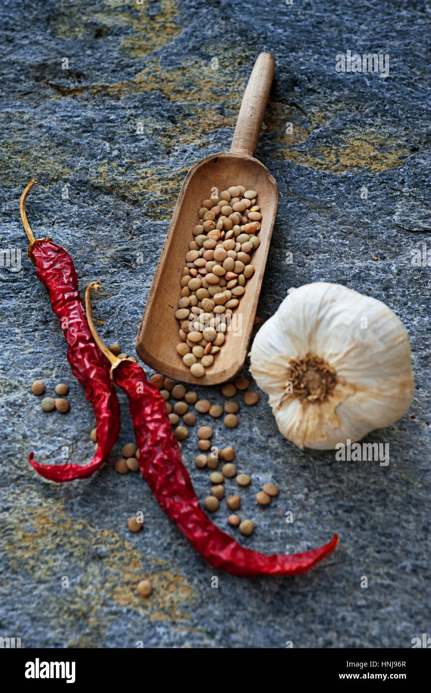 Nourriture rustique toujours avec les lentilles, les poivrons et l'ail sur un arrière-plan en pierre Banque D'Images