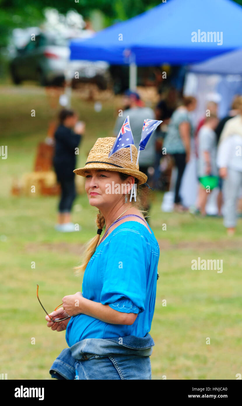 Pensive jolie femme portant deux drapeaux australiens dans son chapeau sur l'Australie Day 2017 , Berrima, New South Wales, Australie Banque D'Images