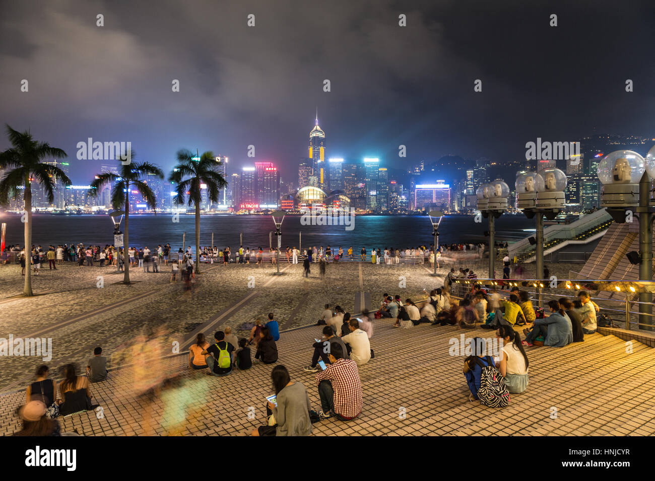 HONG KONG - le 2 octobre 2015 : les gens, capturé avec blurred motion, profitant de la célèbre ligne d'horizon de Hong Kong à partir de l'Avenue des Stars à Kowloon dans la nuit Banque D'Images