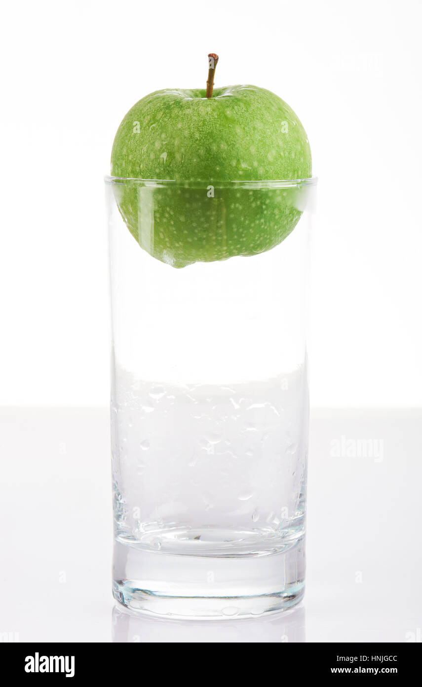 Verre vide avec apple vert isolé sur fond blanc Banque D'Images