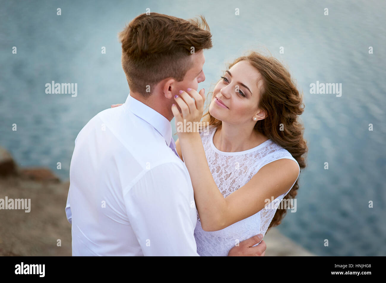 Bride and Groom embrassant au bord du lac pour une promenade Banque D'Images