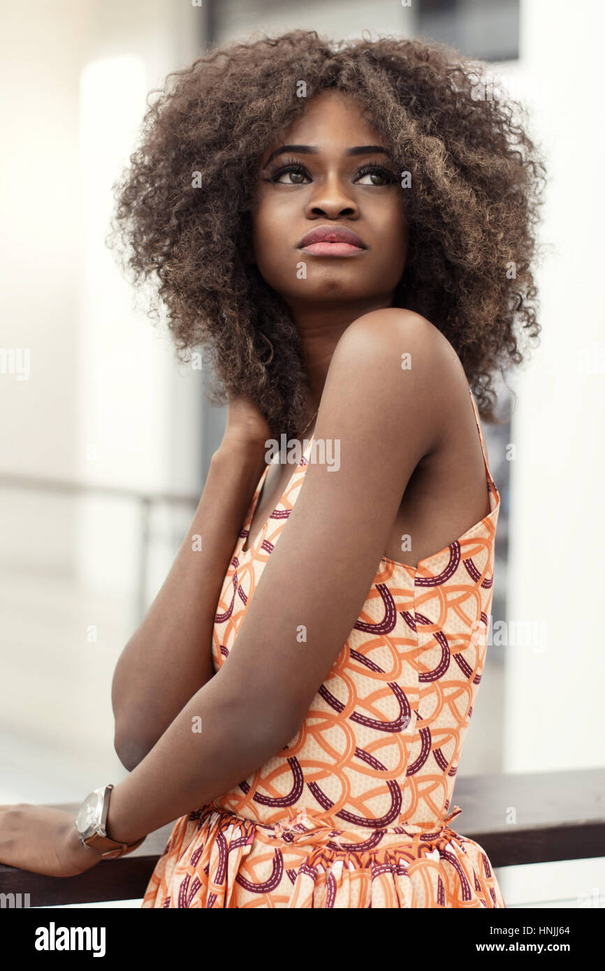 Aux cheveux bouclés afro-American girl à la recherche de l'appareil photo.  Dark peau brillante Photo Stock - Alamy
