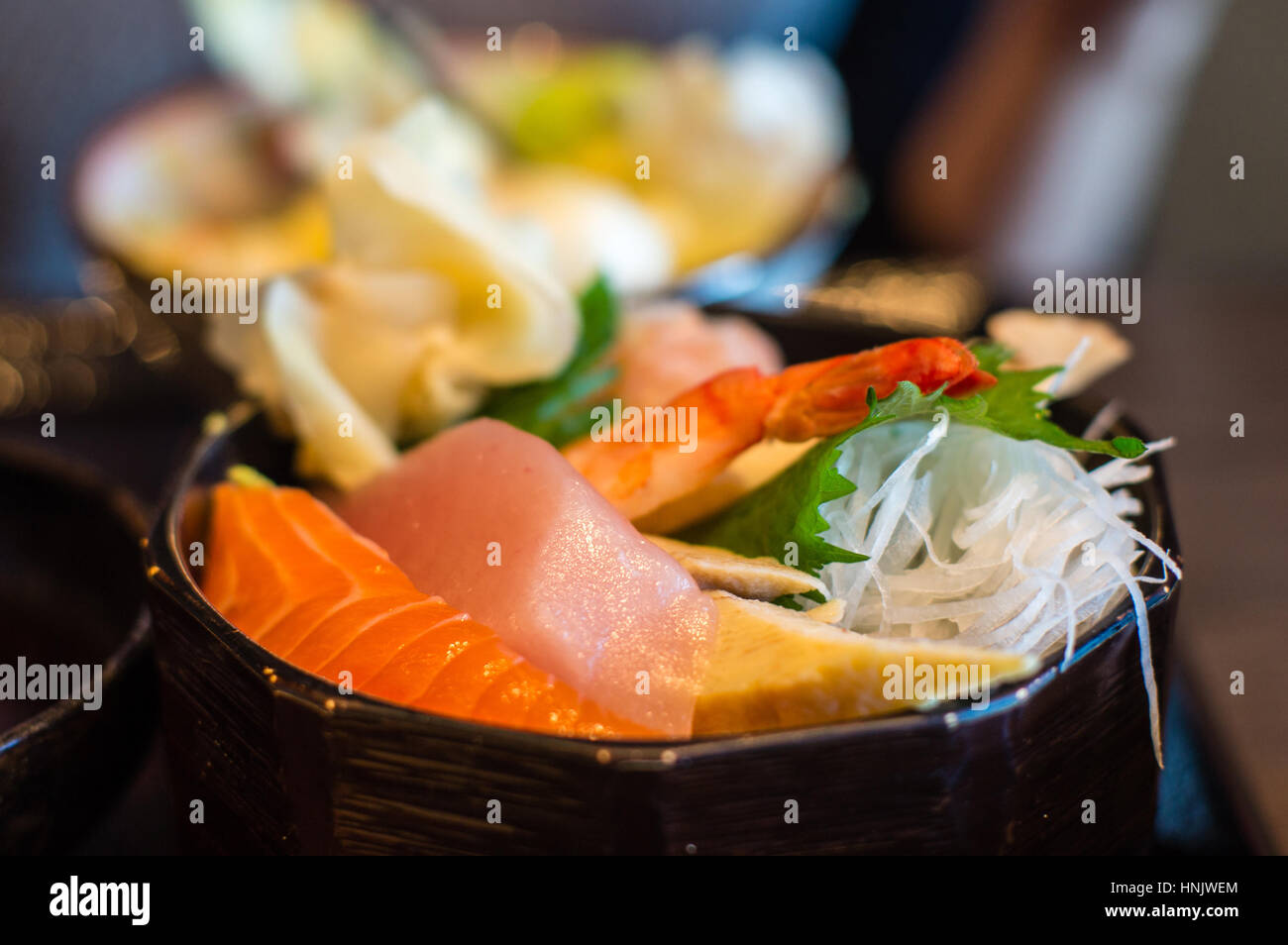 Libre de Japonais sashimi chirashi bol à riz avec crevettes (EBI), maguro (thon), sake (saumon) et des oeufs (omelettes tamago). L'accent délibéré et sh Banque D'Images