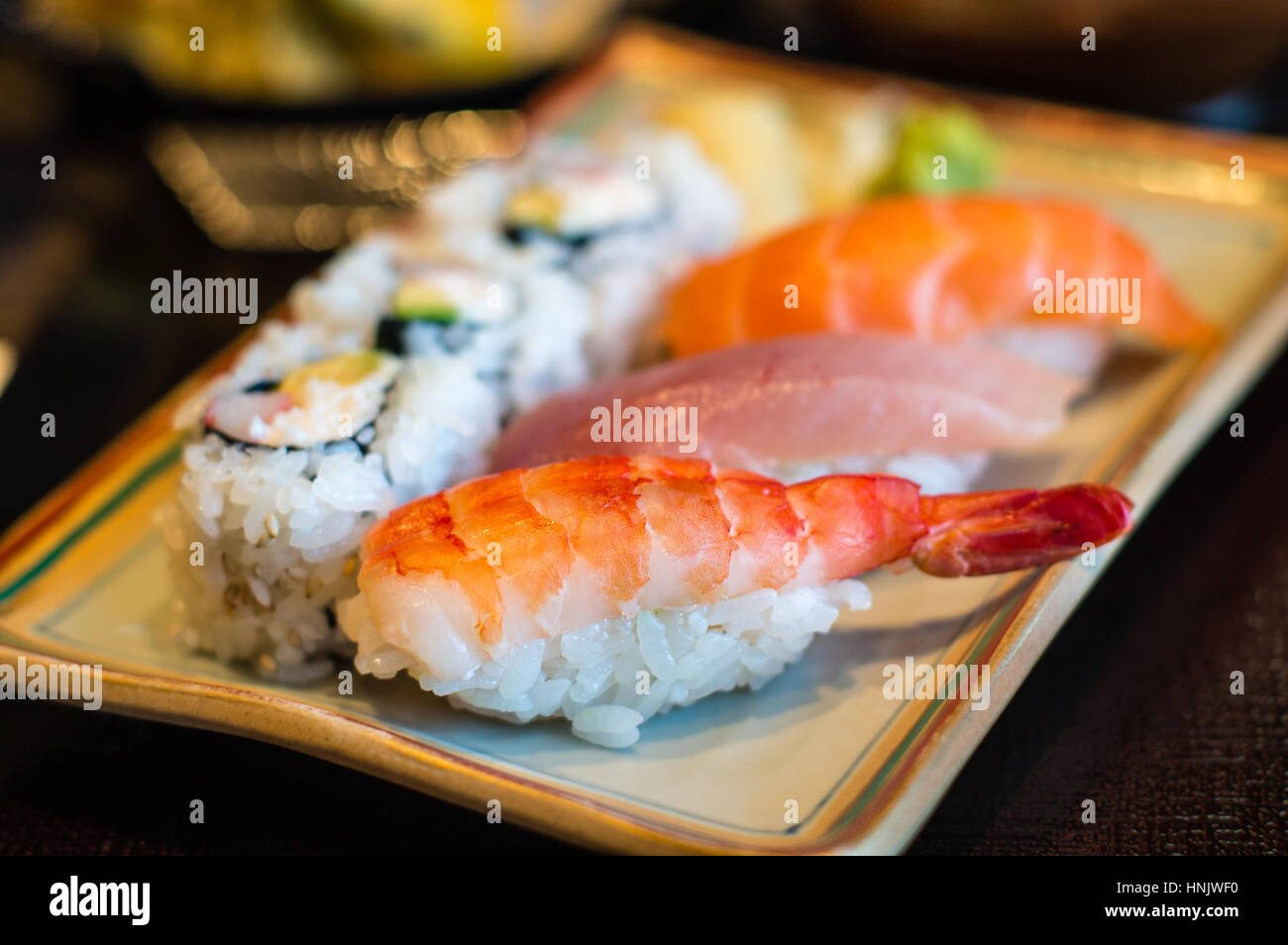 Gros plan du nigiri sushi riz japonais avec plaque de crevettes (EBI) sushi, maguro (thon) et sushi sake (saumon) sushi, avec la Californie. Delibera Banque D'Images