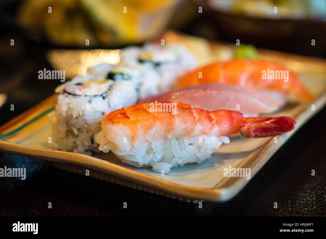 Gros plan du nigiri sushi riz japonais avec plaque de crevettes (EBI) sushi, maguro (thon) et sushi sake (saumon) sushi, avec la Californie. Delibera Banque D'Images