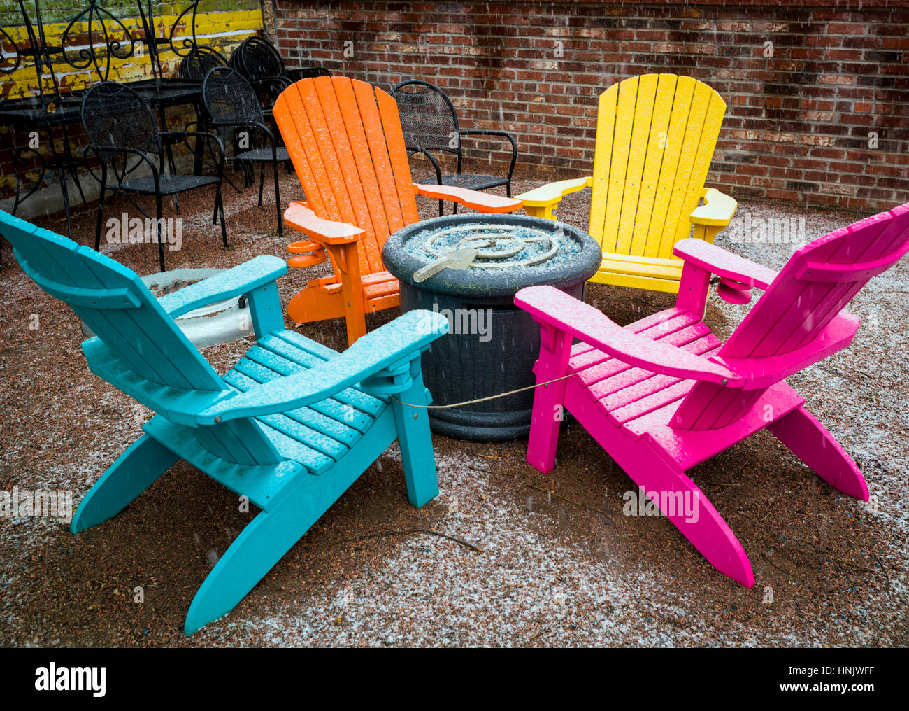 Chaises d'extérieur coloré dans la neige sur patio de Boathouse restaurant Cantina ; Salida, Colorado : USA Banque D'Images