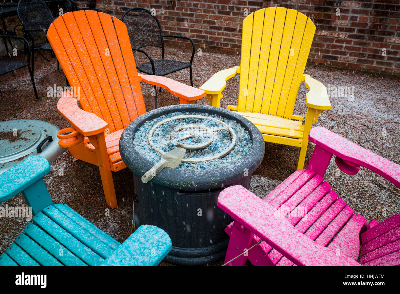 Chaises d'extérieur coloré dans la neige sur patio de Boathouse restaurant Cantina ; Salida, Colorado : USA Banque D'Images