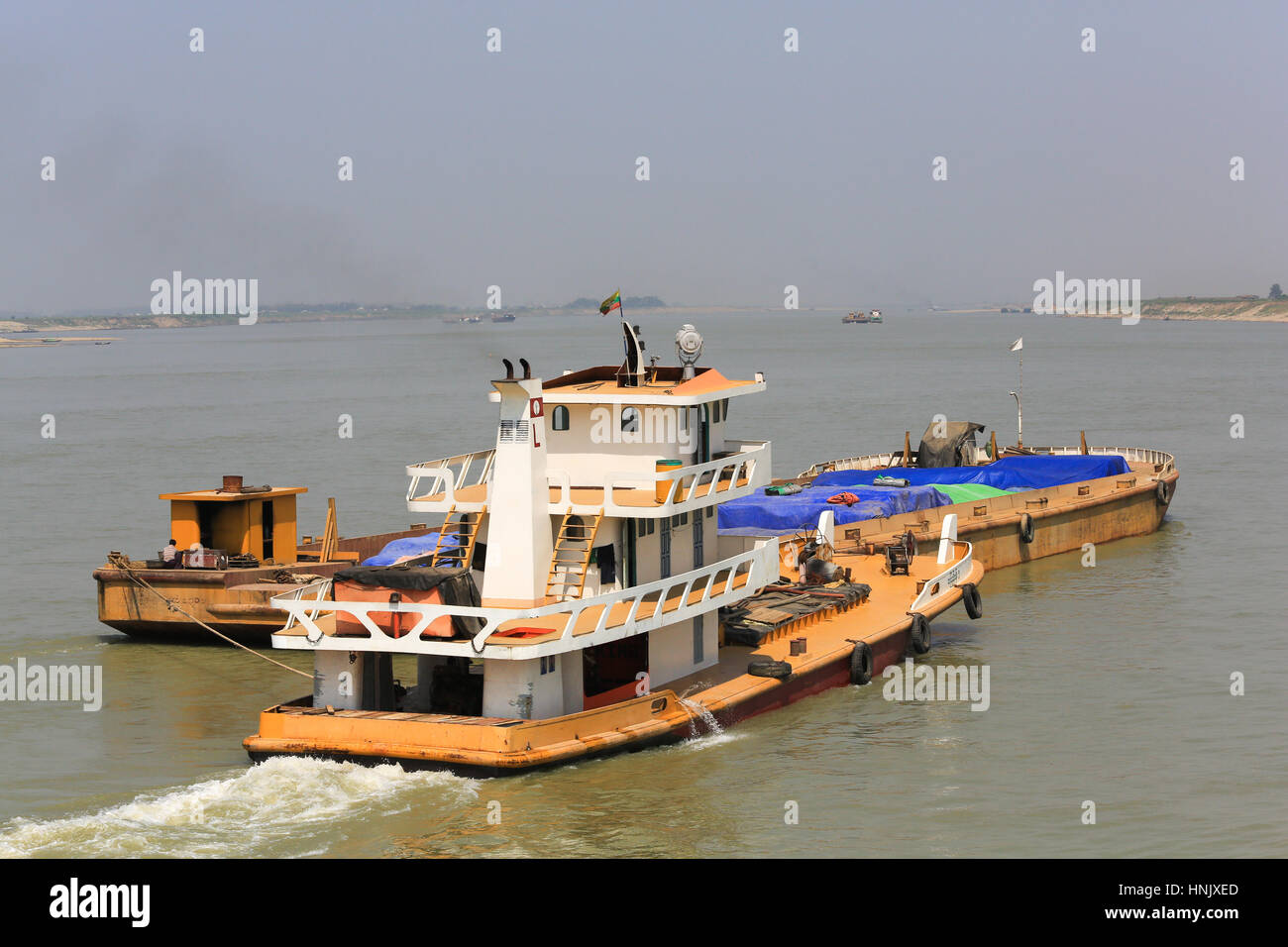 Trois remorqueurs poussent des barges sur le fleuve Irrawaddy en Birmanie (Myanmar). Banque D'Images