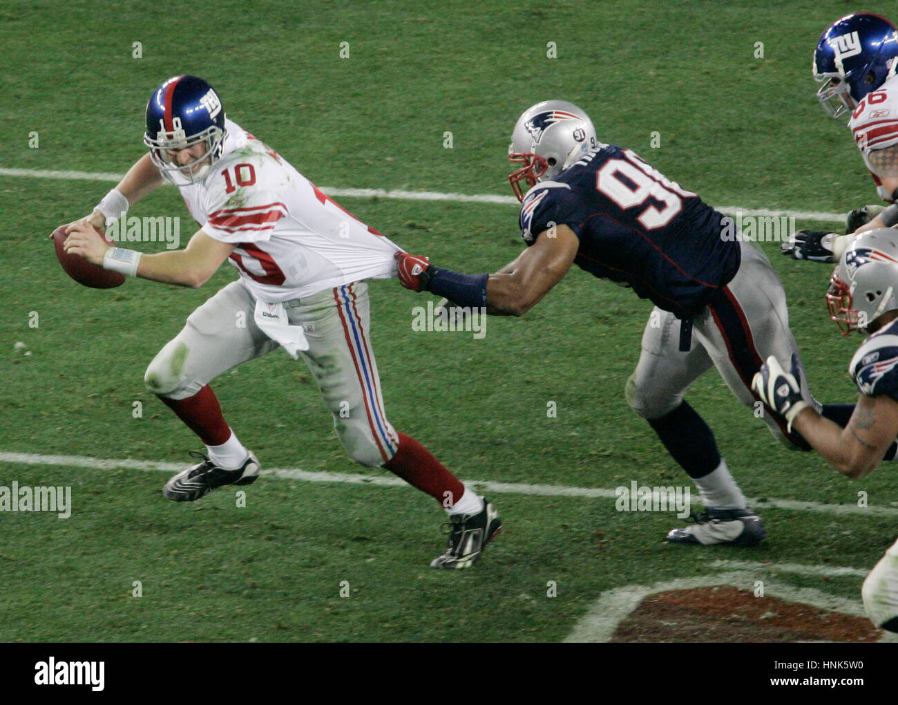 Les New York Giants Eli Manning, à gauche, est attrapée par New England Patriots Rashad Moore au cours du quatrième trimestre de Super Bowl XXLII à Glendale, AZ le dimanche, 3 février, 2008. Photo par Francis Specker Banque D'Images