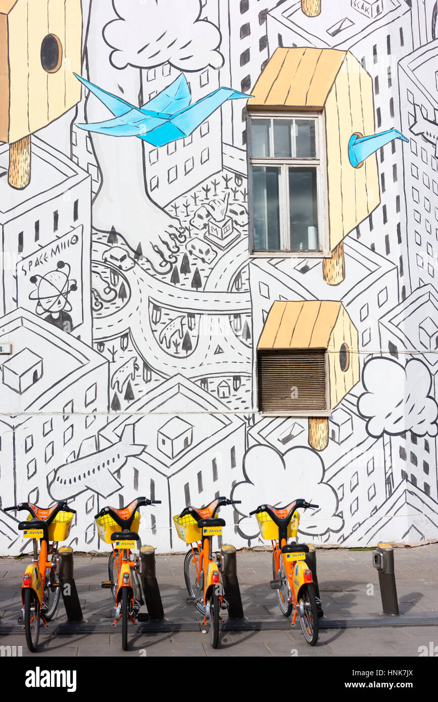 Fresque peinte sur le côté d'un immeuble au centre de Vilnius, avec location de vélos à l'avant-plan. Banque D'Images