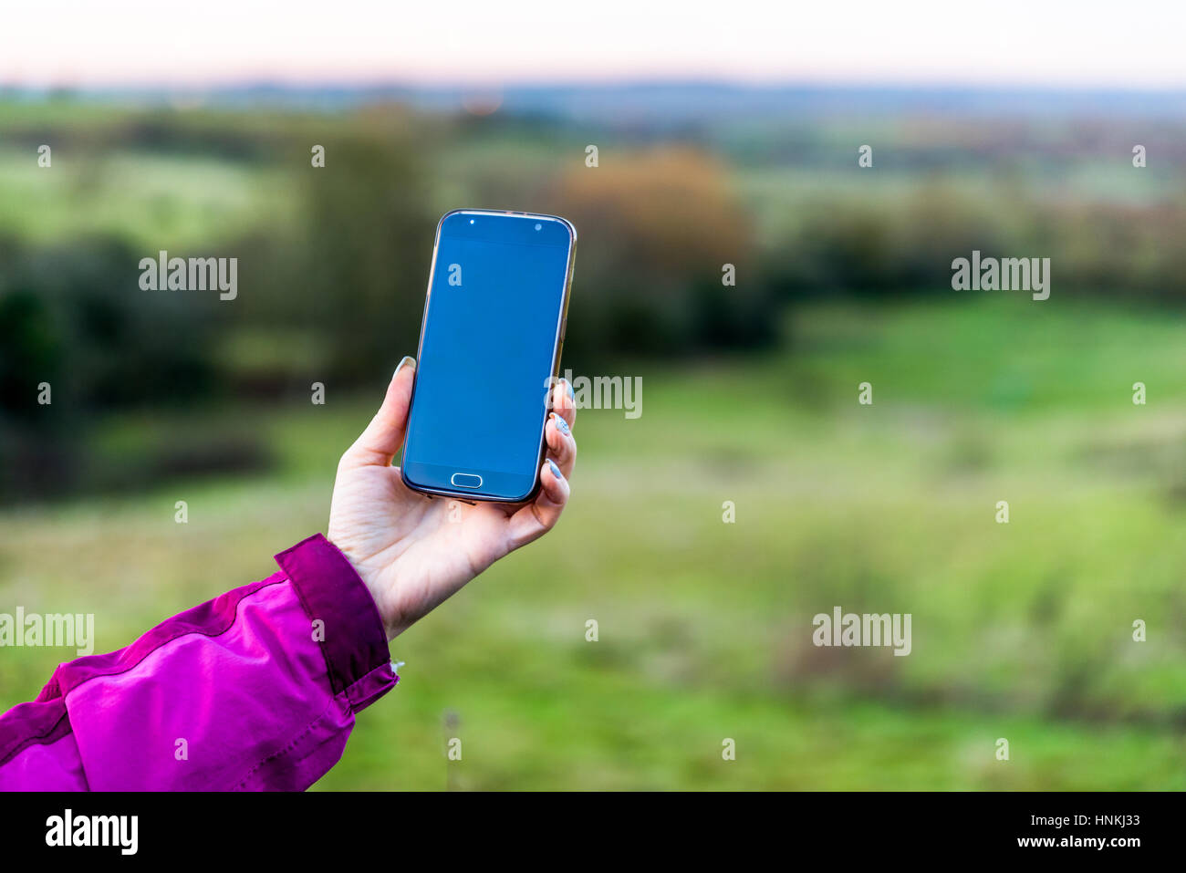 La vue quotidienne de woman holding smartphone partout dans pays déposées en UK. Banque D'Images