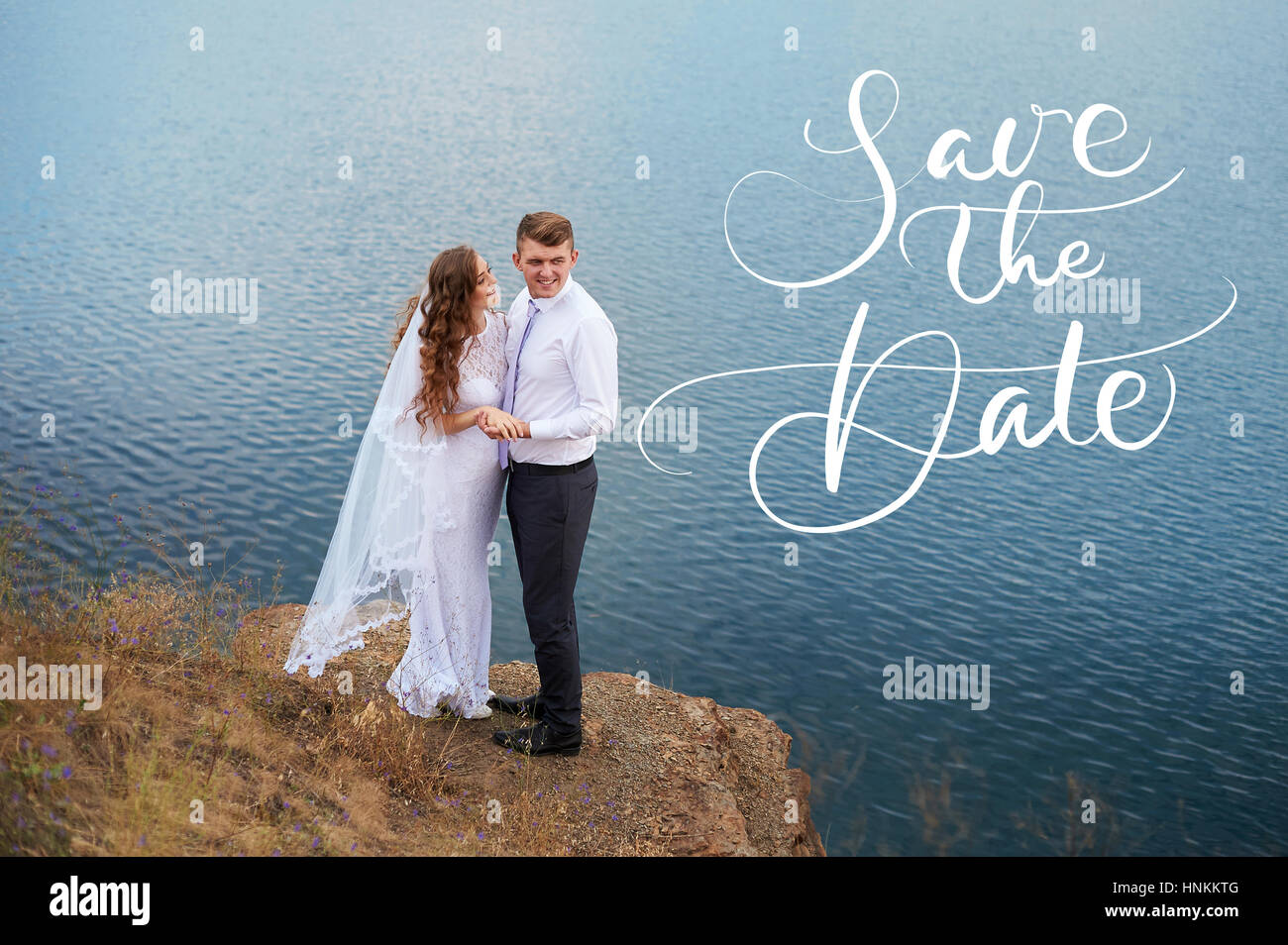 Beau couple de jeunes mariés à wedding à pied par le lac et mots Réservez la date. Lettrage calligraphie Banque D'Images