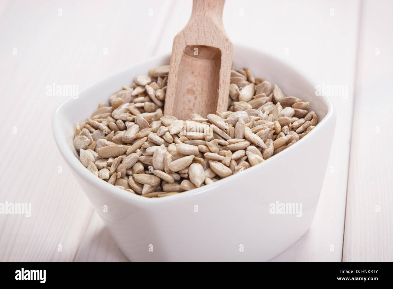 Bol blanc avec des graines de tournesol contenant du zinc et de fibres alimentaires sur les tableaux blancs, les sources naturelles de minéraux, mode de vie sain et nutrition Banque D'Images