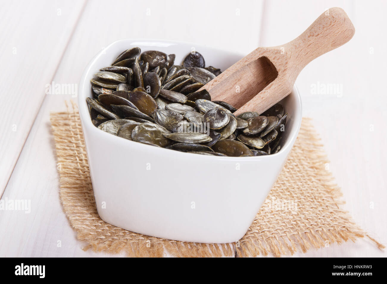 Bol blanc avec les graines de citrouille contenant du zinc et de fibres alimentaires sur les tableaux blancs, les sources naturelles de minéraux, mode de vie sain et nutrition Banque D'Images