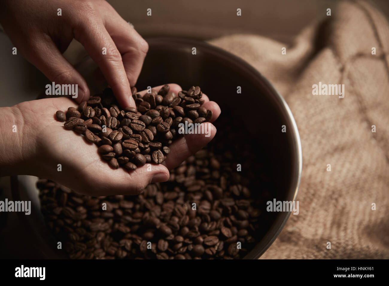 Un café. Une personne titulaire d'une poignée de grains de café torréfié. Banque D'Images
