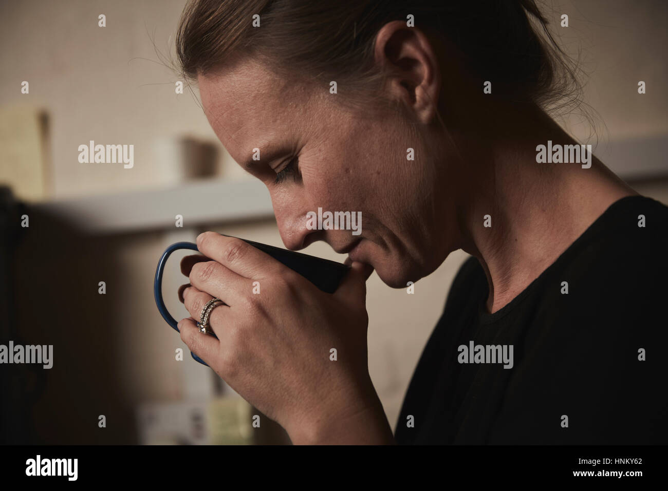 Une femme tenant une tasse de café fraîchement moulu à son nez. Banque D'Images