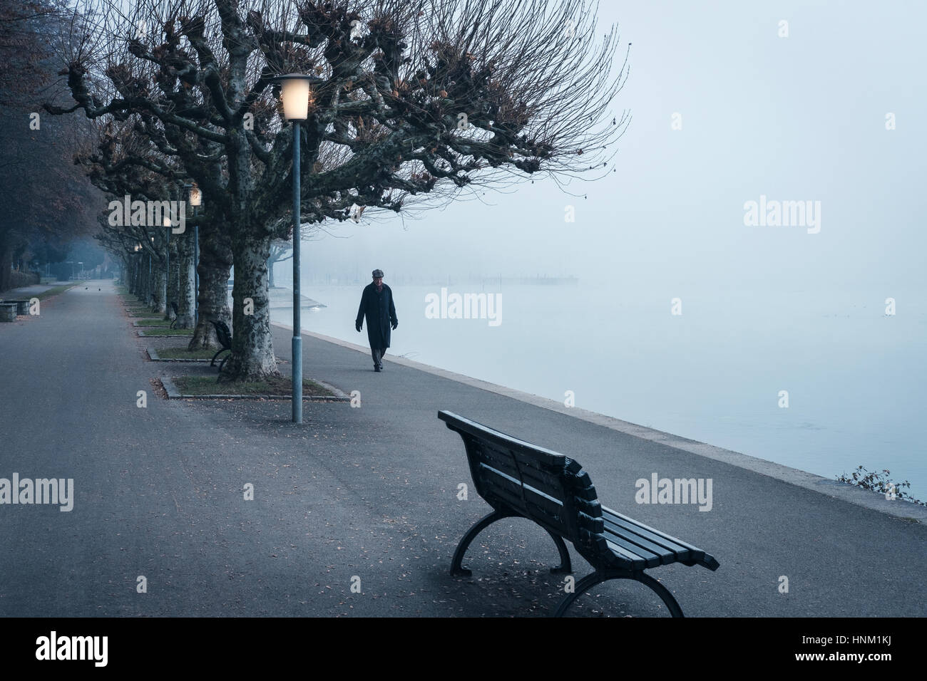 Hauts homme marche le long de la promenade tôt le matin, le lac de Constance Bodensee,Grmany, Banque D'Images