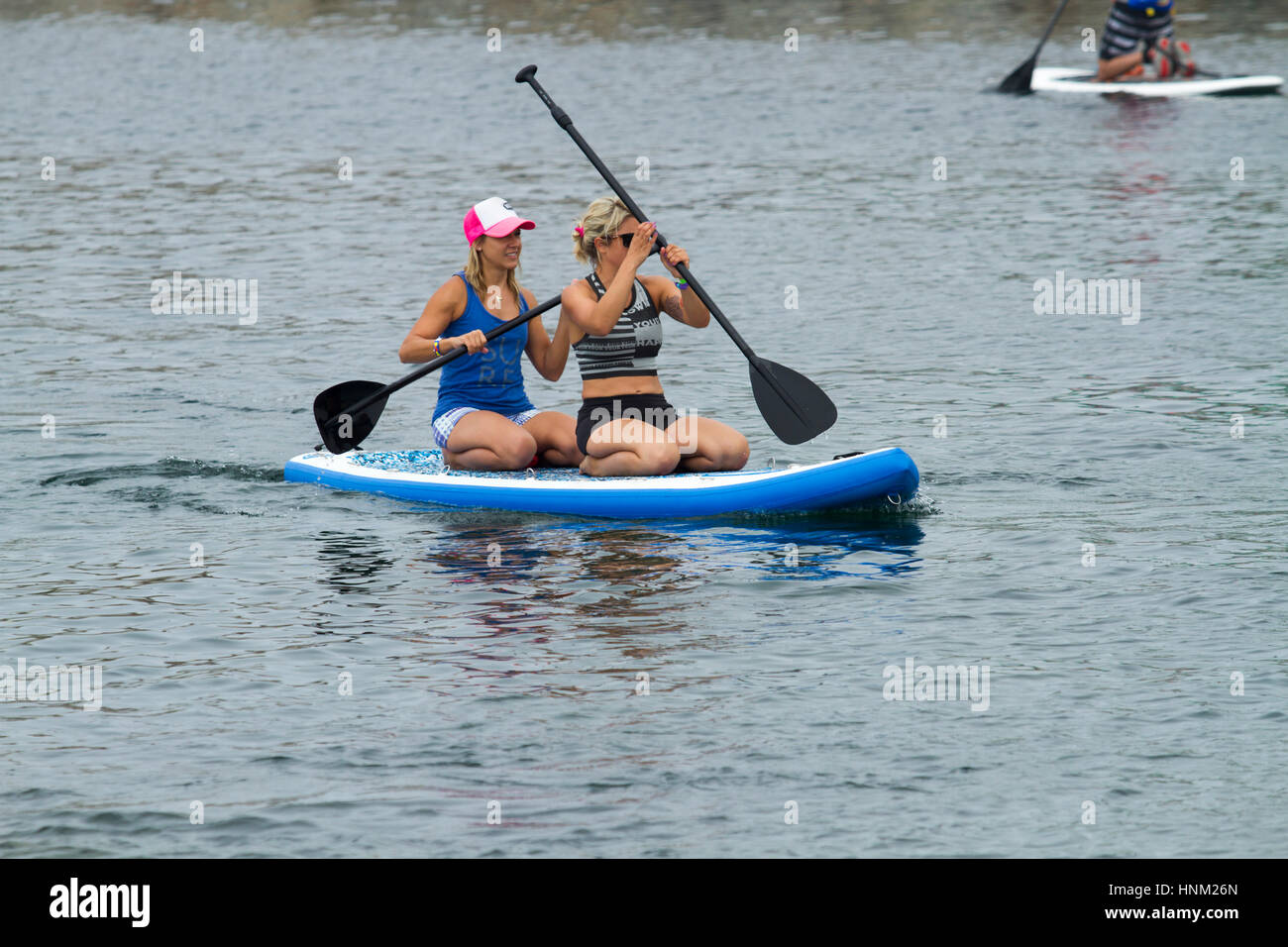 Deux athlètes femmes partageant une paddleboard Banque D'Images