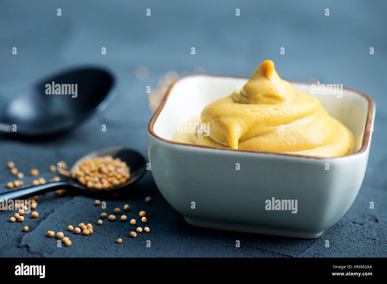 La moutarde dans un bol et sur une table Banque D'Images