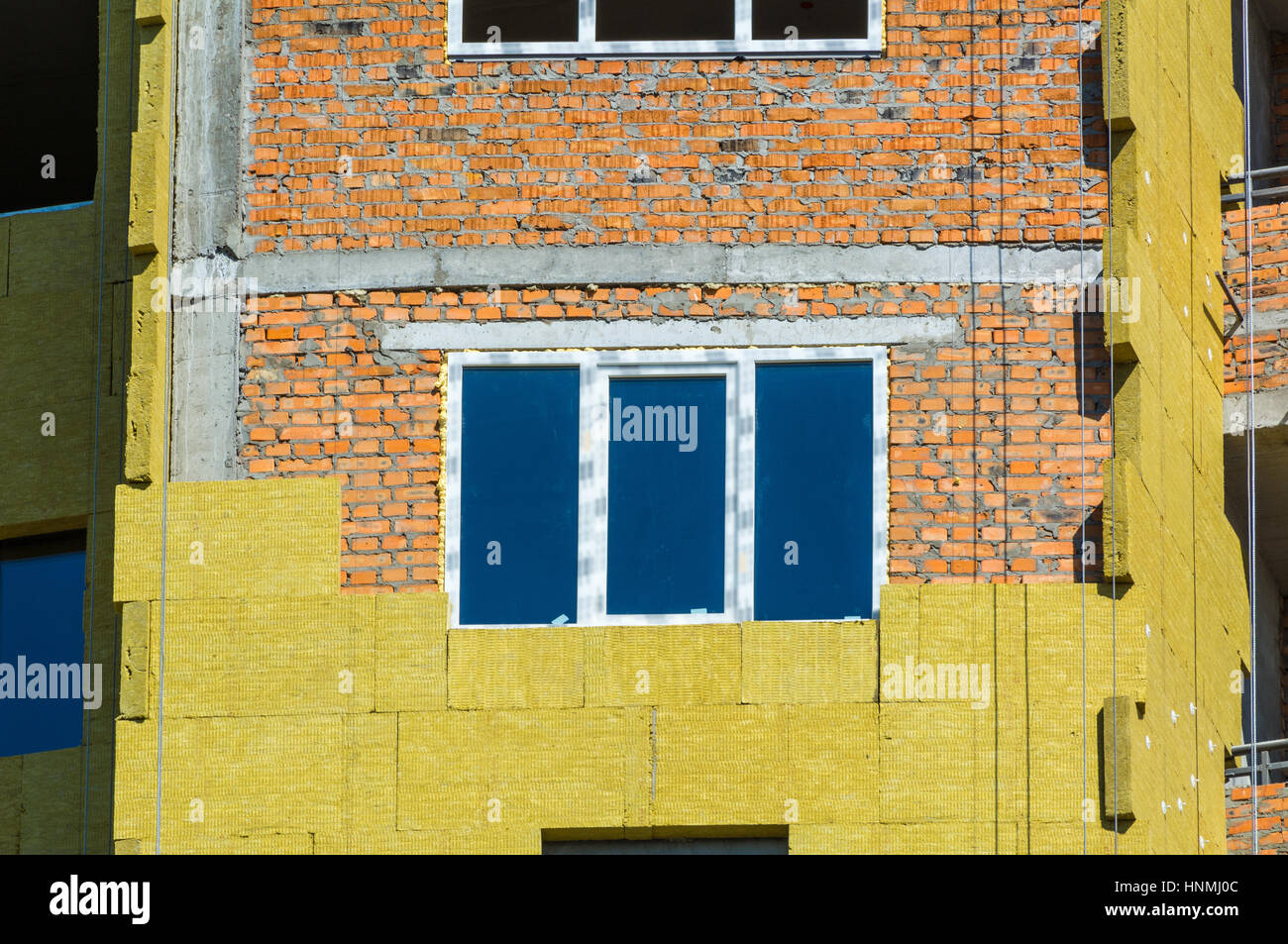 Travail à haute altitude sur les murs extérieurs de l'isolation en laine de verre et de plâtre Banque D'Images