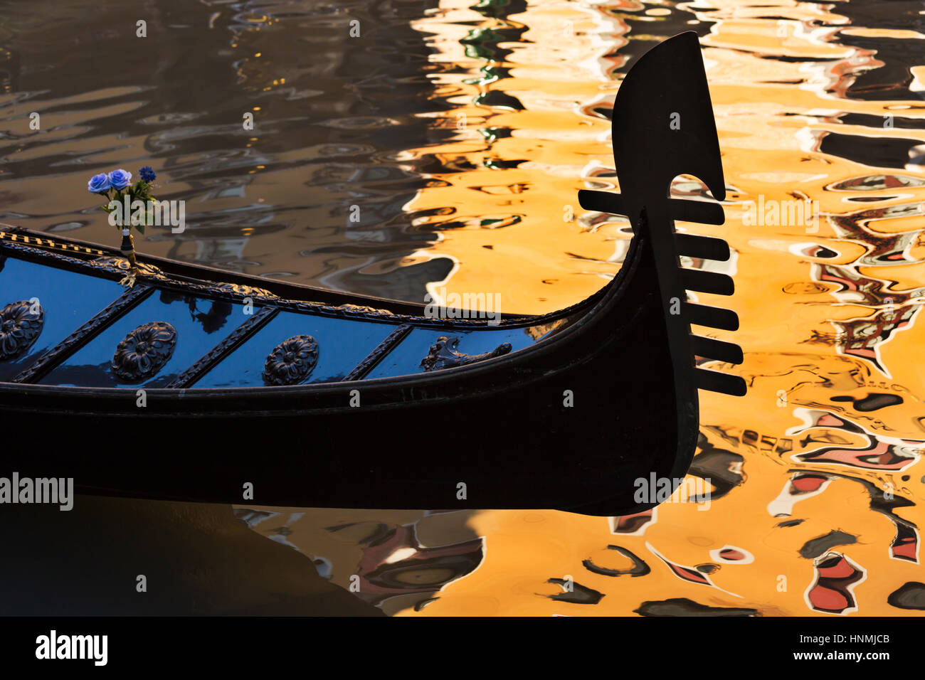 Gondola détail dans la lumière du soleil d'Or avec reflets du bâtiment dans l'eau à Venise, Italie en janvier Banque D'Images