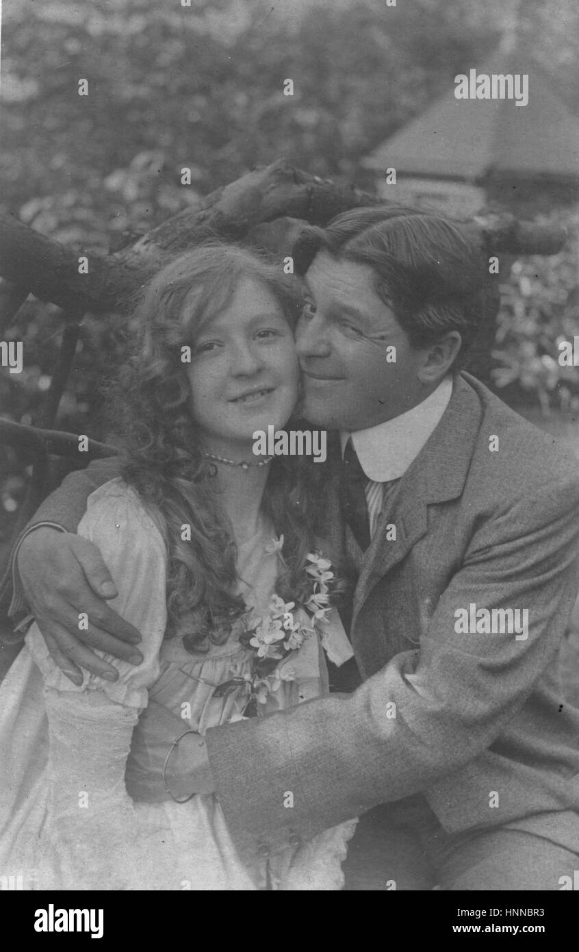 Amoureux embrassant, couple heureux. Il est en méclage, elle sourit. Notez son col étoilé et ses cheveux partés au milieu.1906, Elle semble être 60 ans avant ses sœurs 'fleur fille' des années 1960. Pour voir mes autres images anciennes, recherchez : Préstor vintage Banque D'Images
