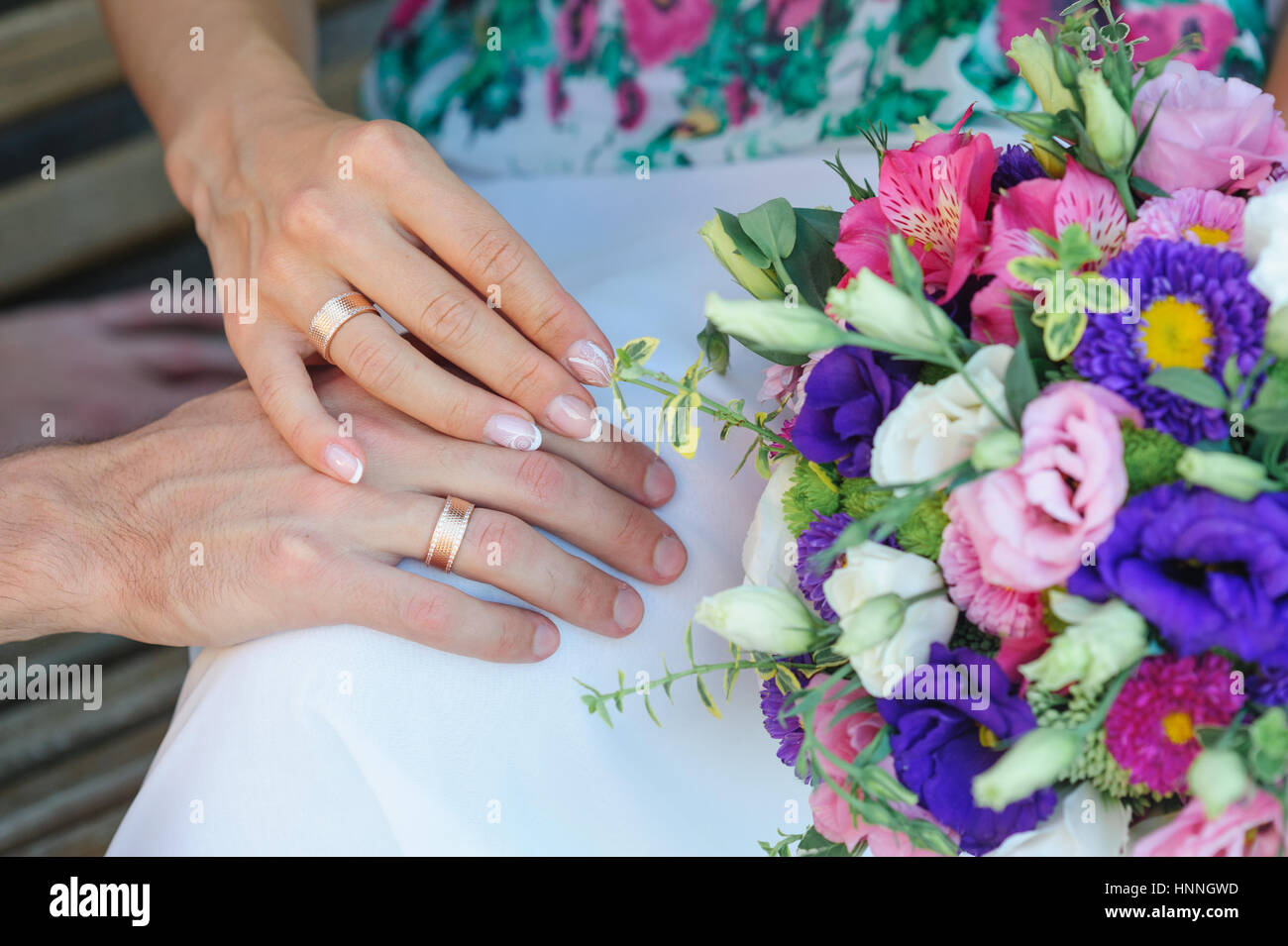 Mains de mariée et le marié avec joints toriques et bouquet de mariage Banque D'Images