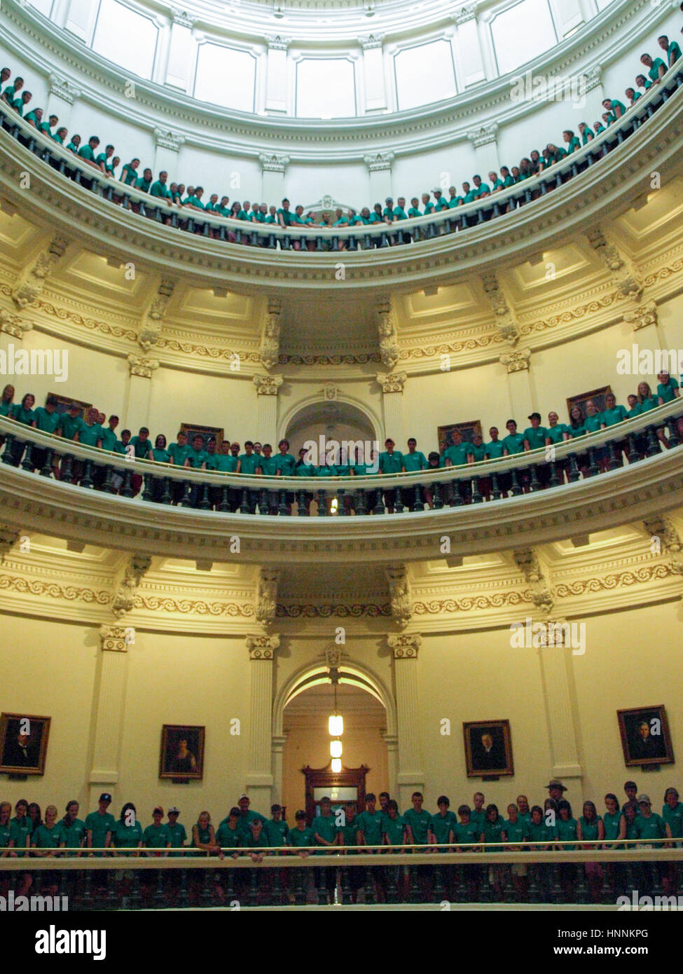 Un grand groupe d'école pose pour photo sur trois étages de la rotonde du Capitole.Austin, Texas. Banque D'Images