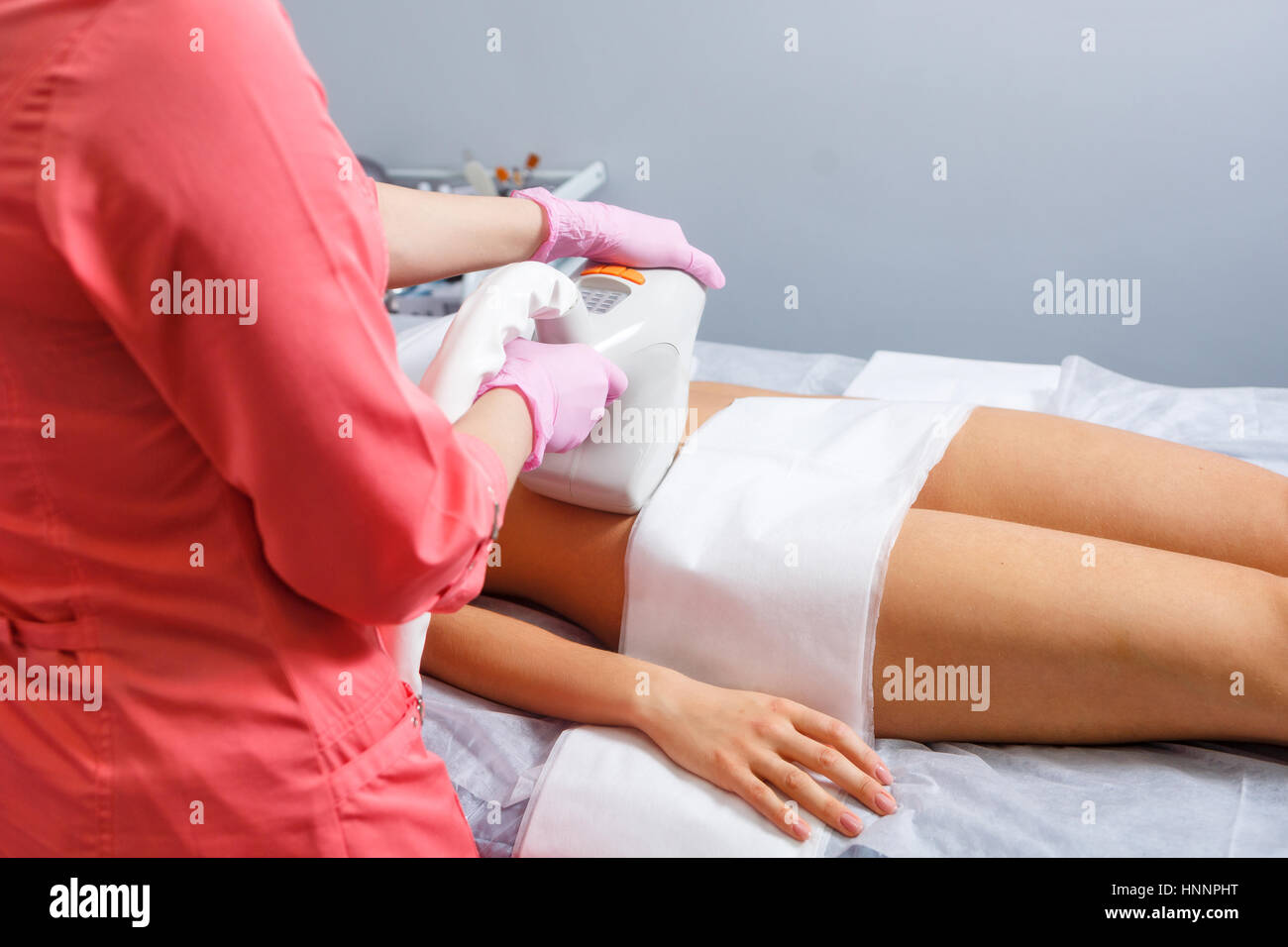 Massage sous vide de l'abdomen d'une jeune fille. Cosmétologie matérielles. Studio Spa. L'homme est méconnaissable. Banque D'Images