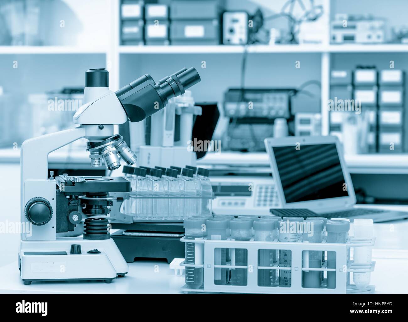 Laboratoire de sciences avec un microscope, des échantillons de matériel biologique et d'un ordinateur sur un bureau. Focus sélectif avec bokeh. Rack avec des échantillons et des produits chimiques Banque D'Images