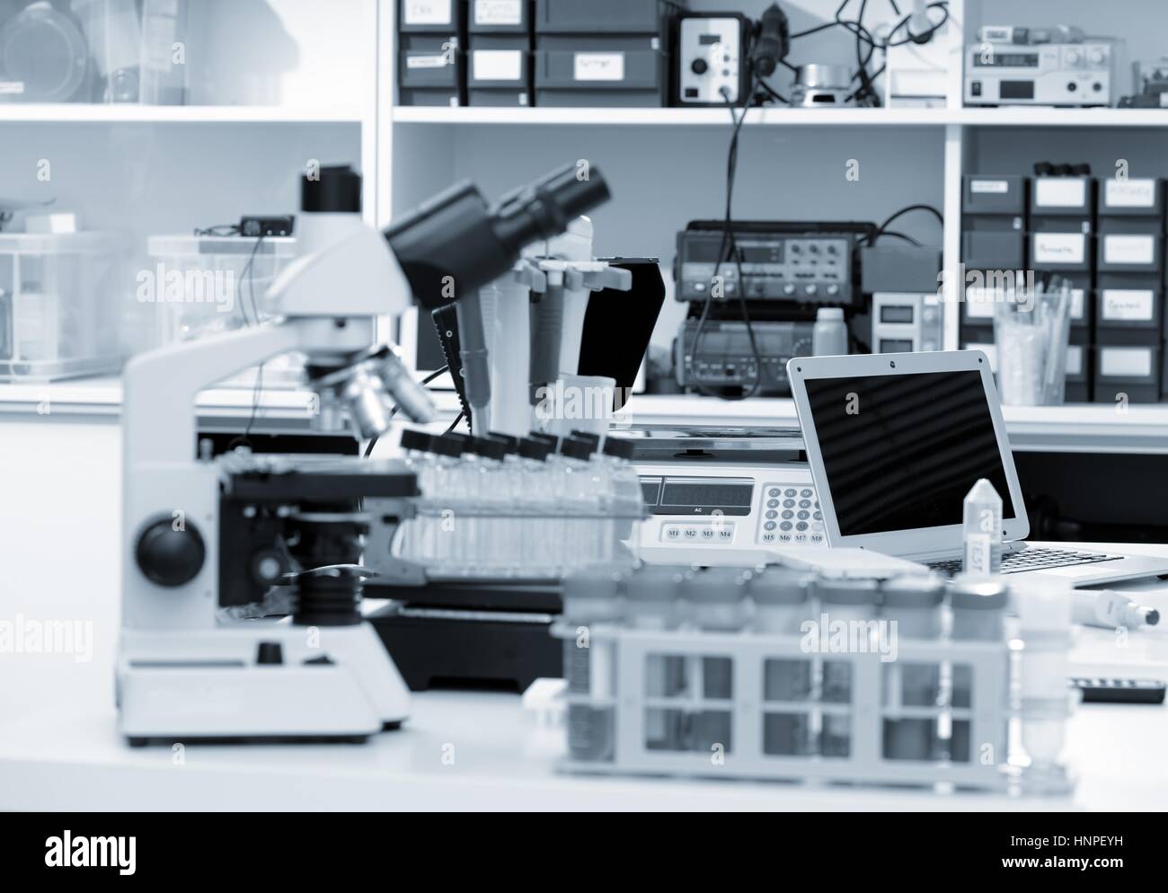 Laboratoire de sciences avec un microscope, des échantillons de matériel biologique et d'un ordinateur sur un bureau. Focus sélectif avec bokeh. Rack avec des échantillons et des produits chimiques Banque D'Images