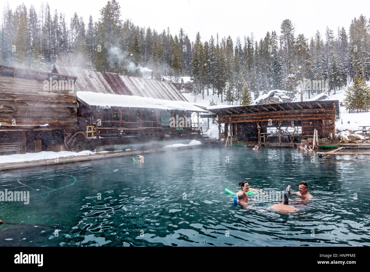 Les gens tremper dans l'eau de 100 degrés de la piscine principale à Burgdorf Hot Springs près de McCall, ID, au cours d'une neige légère. Les ressorts peuvent être atteint en w Banque D'Images