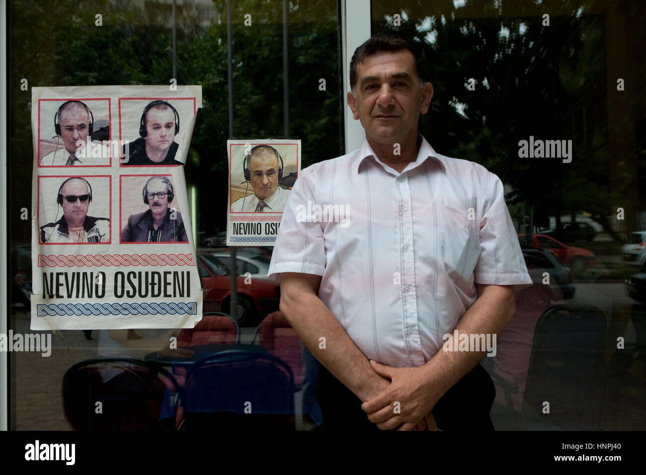 Un croat bosniaque se trouve à côté d'une affiche portant des portraits De généraux croates emprisonnés pour crimes de guerre contre des Serbes pendant La guerre bosniaque entre 1992 et 1995 avec la lecture écrite 'Innocemment condamné' dans la ville de Mostar en Bosnie Banque D'Images