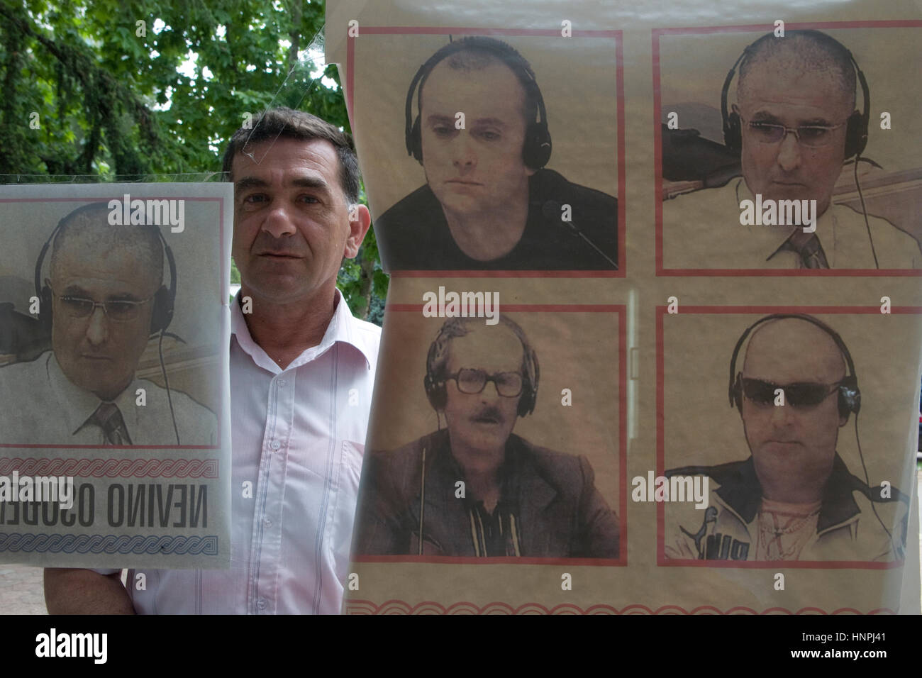 Un croat bosniaque se dresse derrière une affiche portant des portraits De généraux croates emprisonnés pour crimes de guerre contre des Serbes pendant La guerre bosniaque entre 1992 et 1995 avec la lecture écrite 'Innocemment condamné' dans la ville de Mostar en Bosnie Banque D'Images