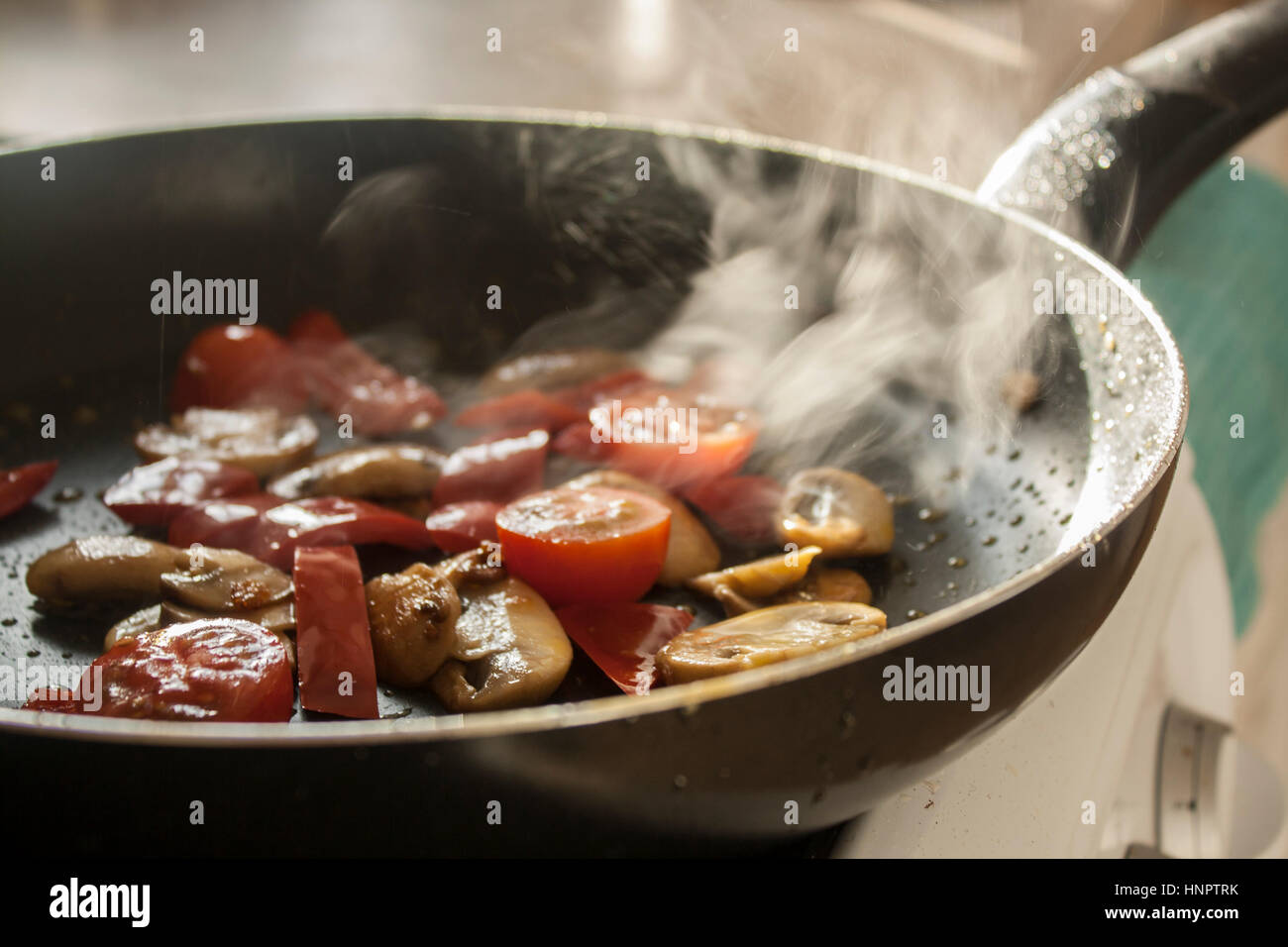 Les tomates et les champignons à la poêle dans une casserole Banque D'Images