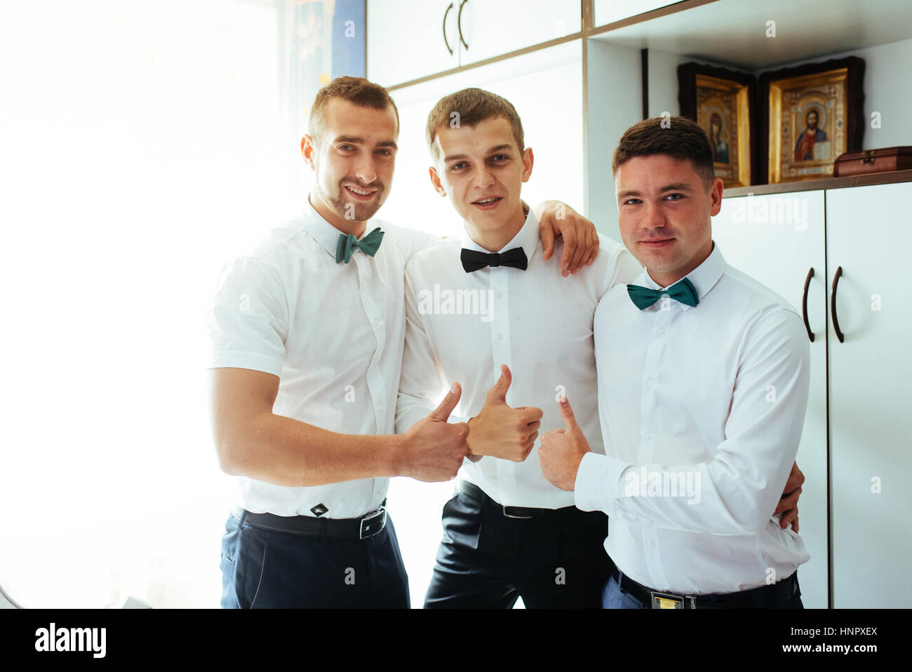 Smiling Caucasian groom standing par fenêtre avec des garçons, getti Banque D'Images
