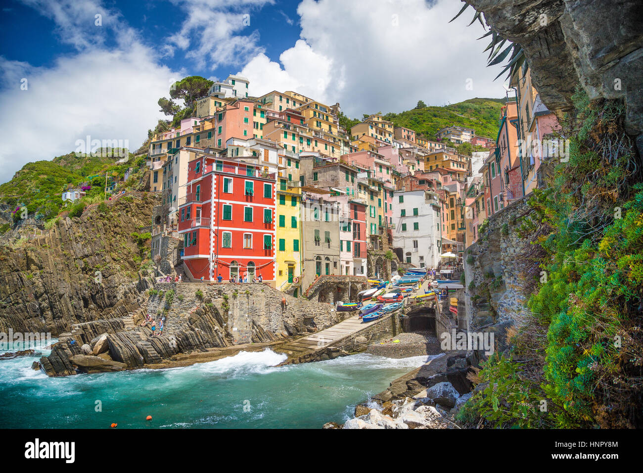 L'affichage classique de belle Riomaggiore, l'un des cinq villages de pêcheurs pittoresque des Cinque Terre, sur une journée ensoleillée avec ciel bleu et nuages Banque D'Images