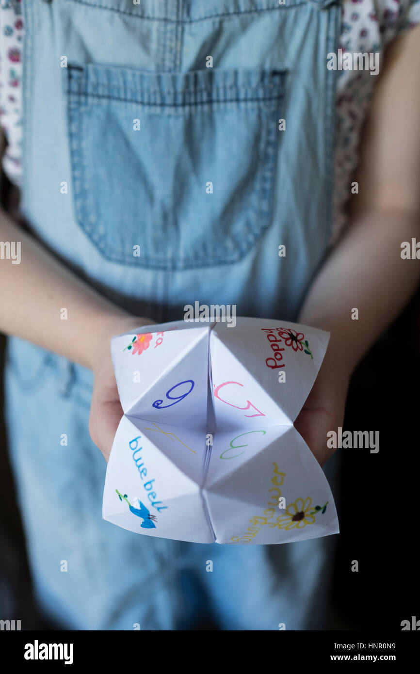 Une fille avec un jeu papier Origami Fortune Teller Banque D'Images