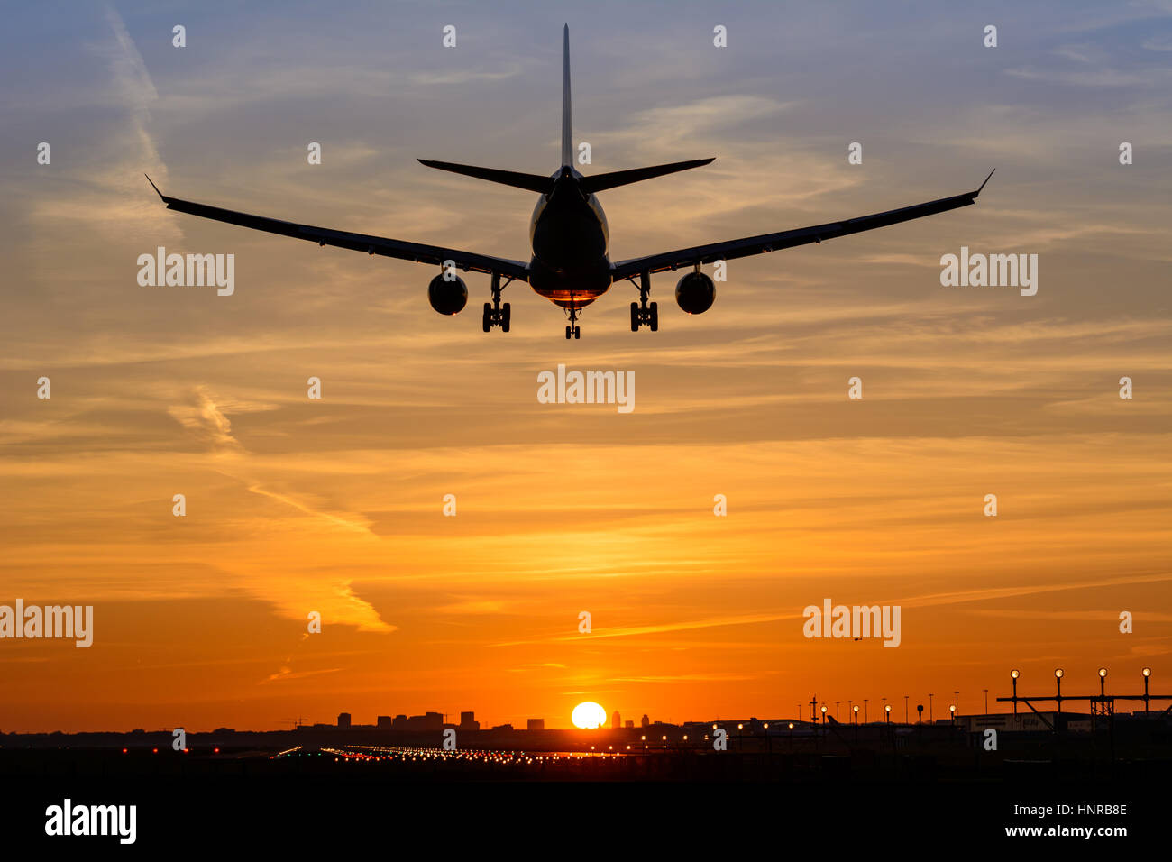 Avion de passagers au cours de l'atterrissage est un magnifique lever du soleil. L'avion est presque posé sur la piste. Banque D'Images