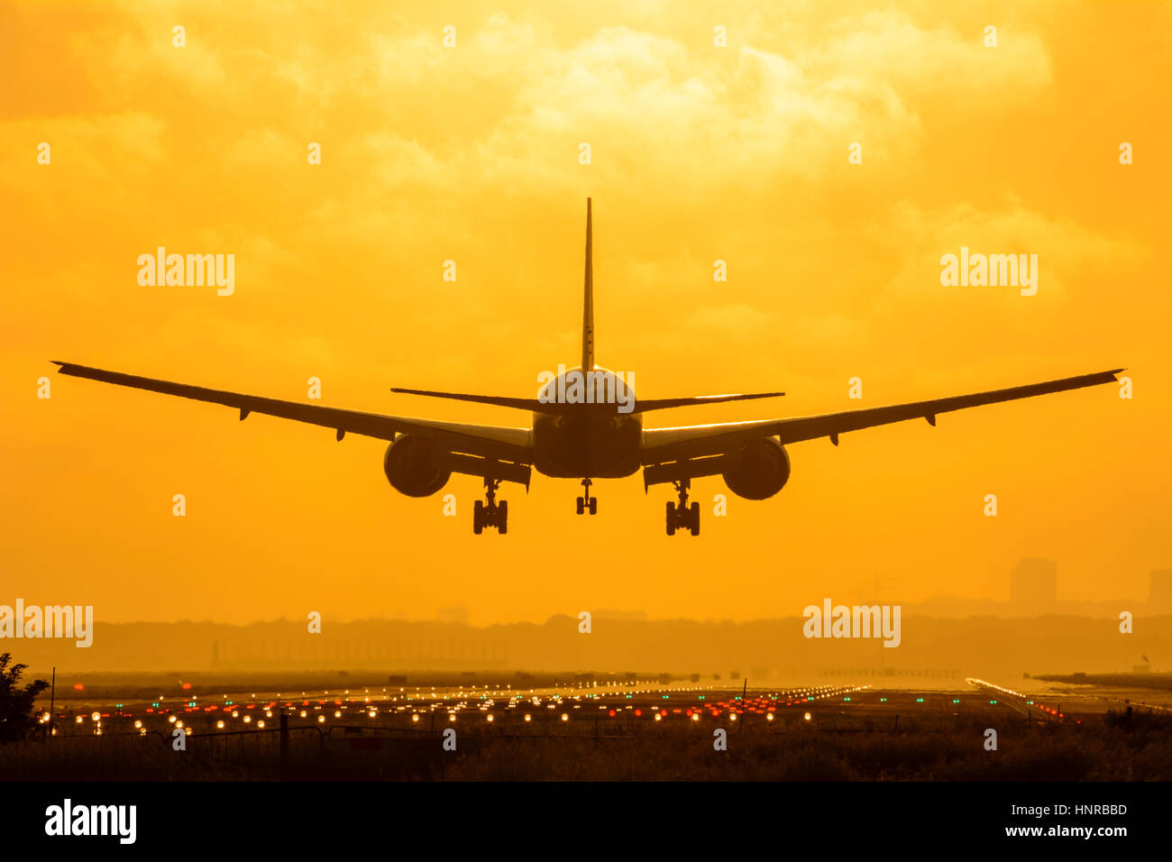 Avion est l'atterrissage pendant le lever du soleil. Photo est prise sur un ciel nuageux le matin tôt. Banque D'Images