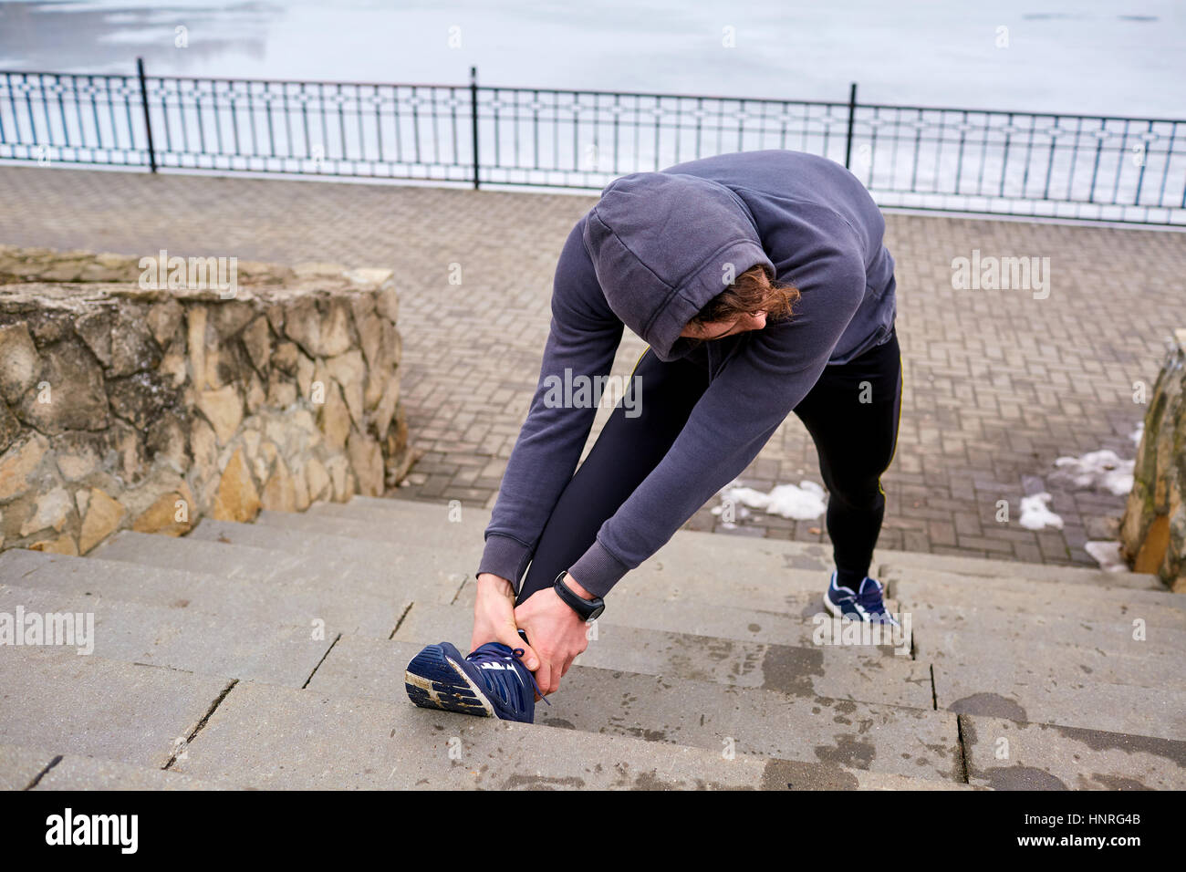 L'homme de l'athlète l'échauffement avant l'exécution. La vie Sport hiver printemps Banque D'Images