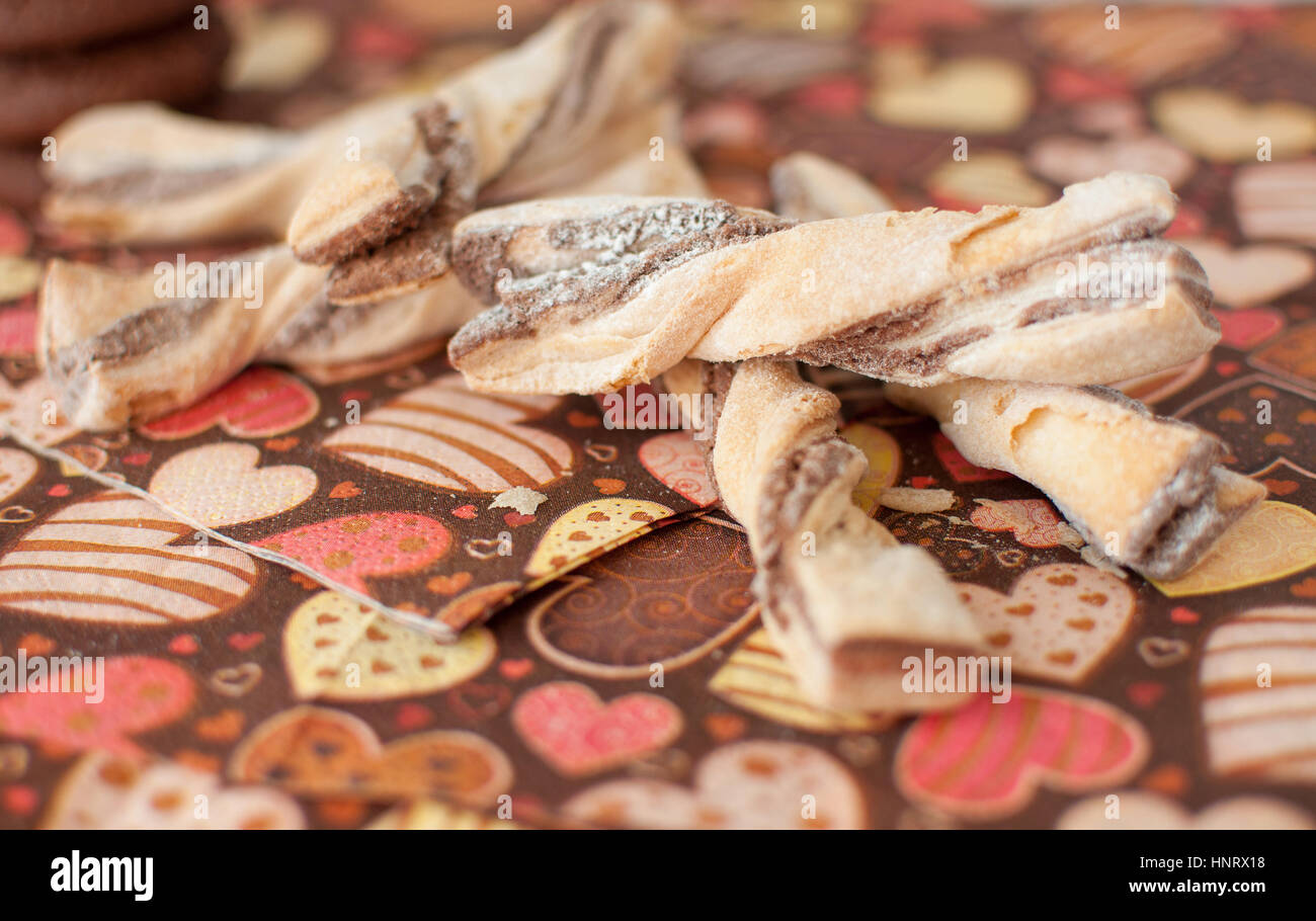 Cookies sur serviette sombre avec l'image du cœur de près. Focus sélectif. Banque D'Images