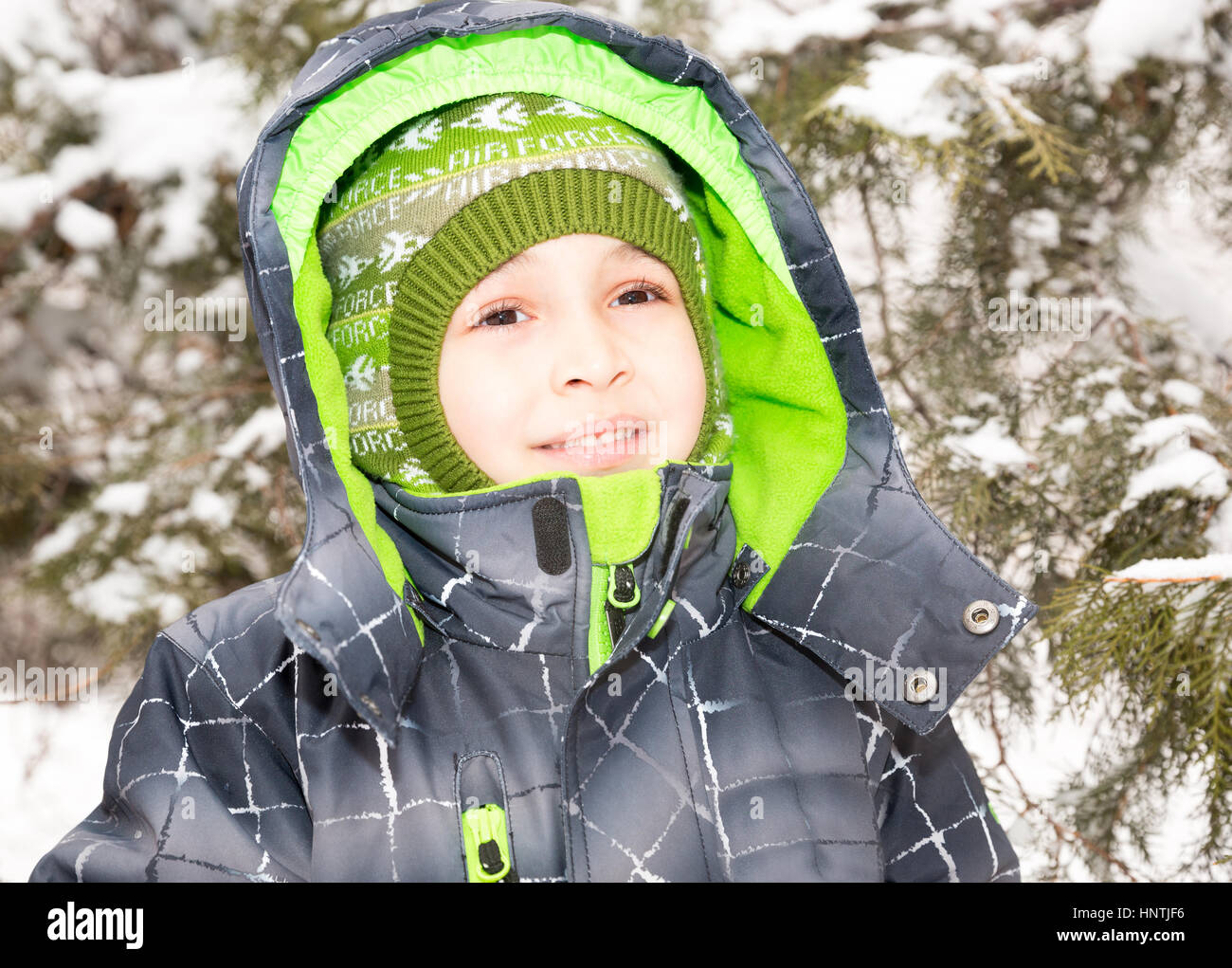 Portrait de l'adorable petit garçon heureux souriant joyeusement à l'appareil photo sur un jour d'hiver ensoleillé Banque D'Images