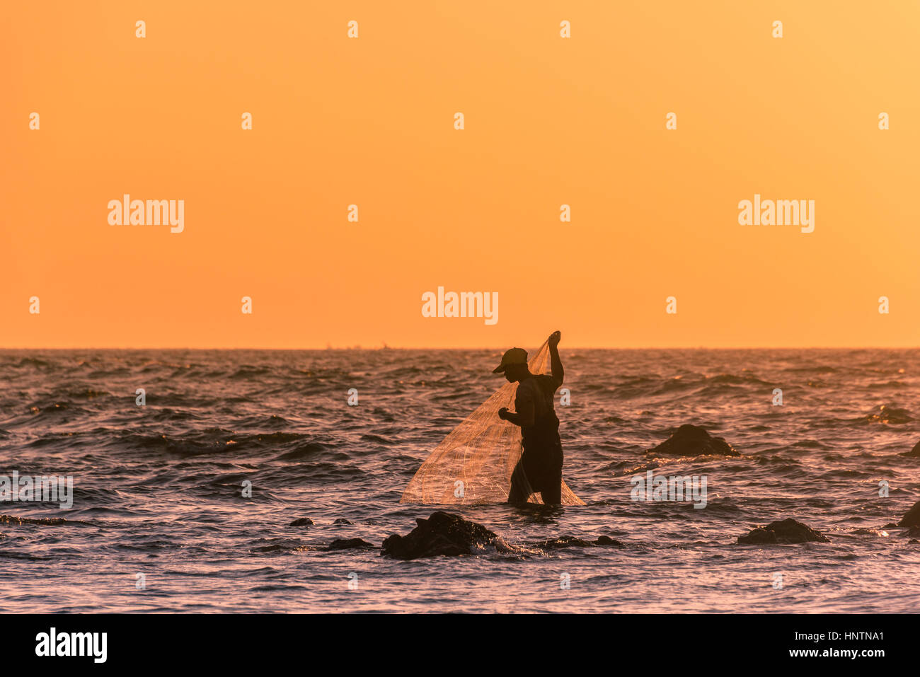 Les pêcheurs locaux avec filet de pêche en contre-jour, le coucher du soleil, Chaung Thar plage, baie du Bengale, de l'Ayeyarwady, au Myanmar Banque D'Images