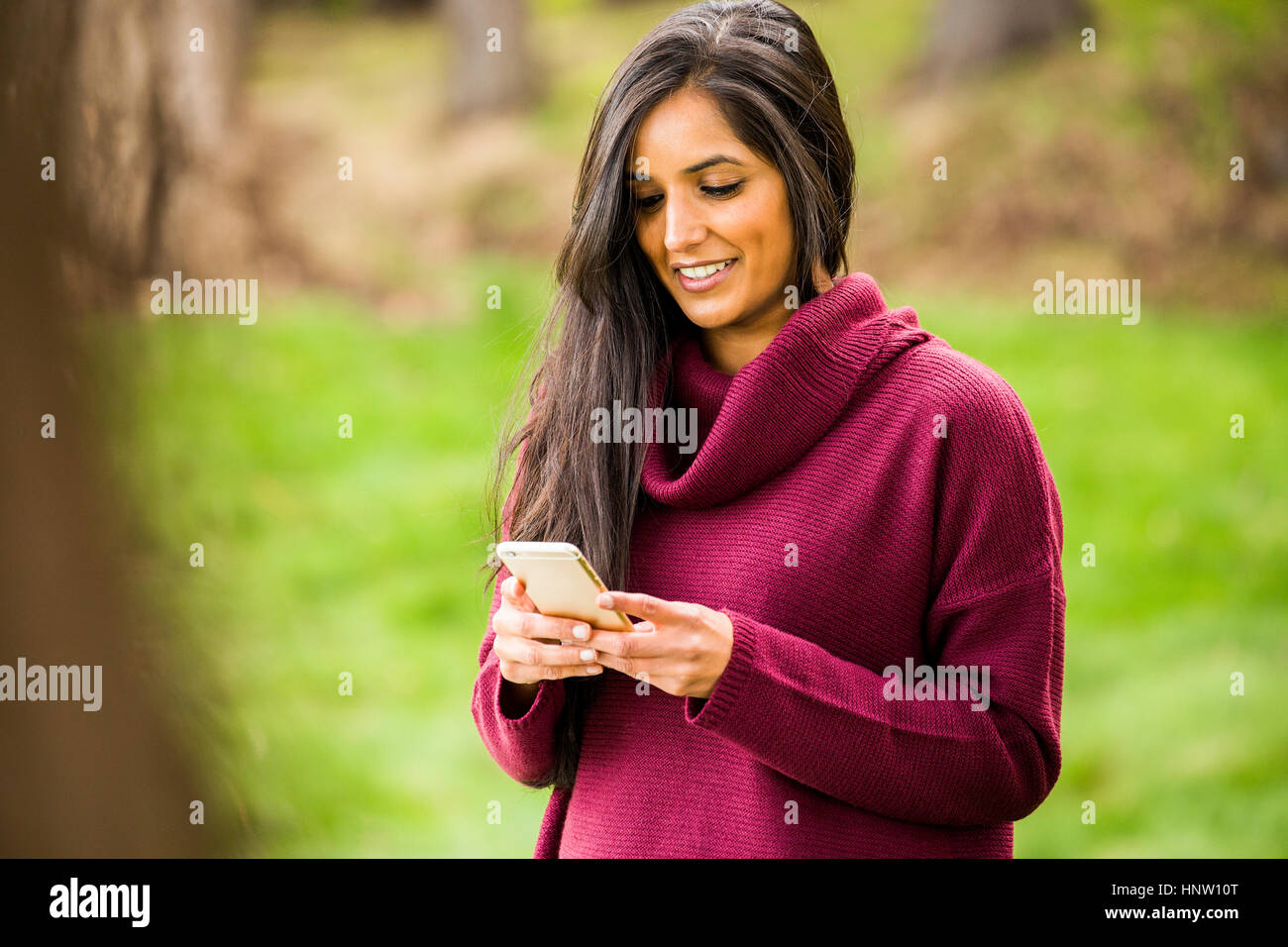 Smiling woman texting on cell phone Banque D'Images