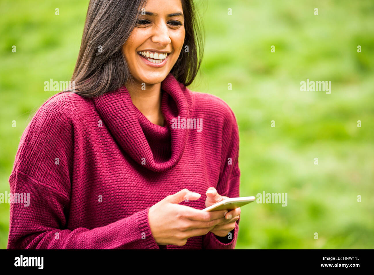 Laughing woman texting on cell phone Banque D'Images