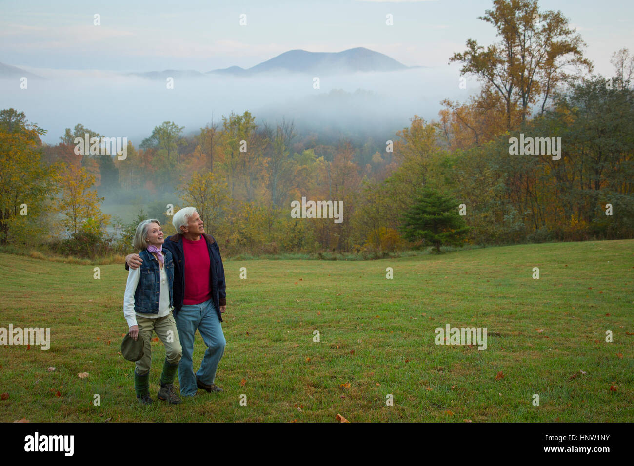 Caucasian couple walking in field Banque D'Images